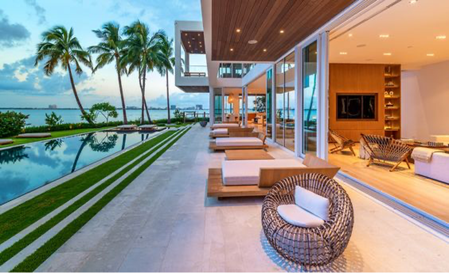 Modern coastal style home in Miami with tall palm trees and ocean views