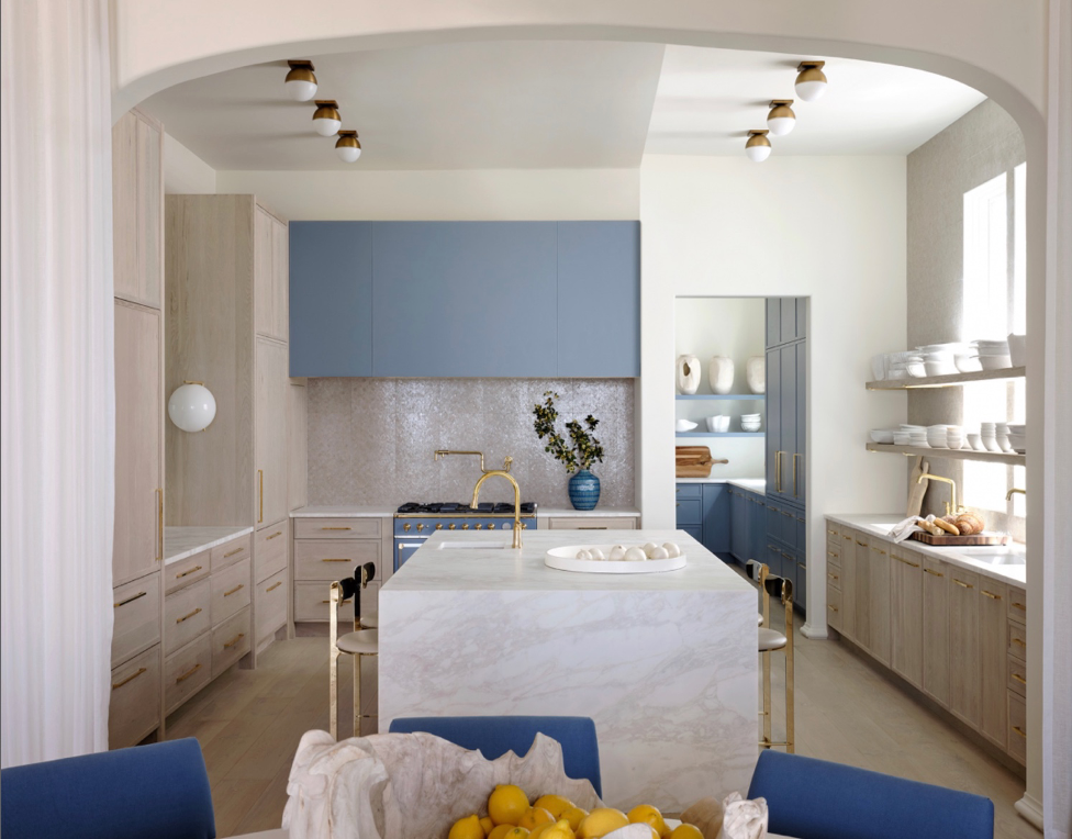 Beach home sleek kitchen with white marble waterfall island