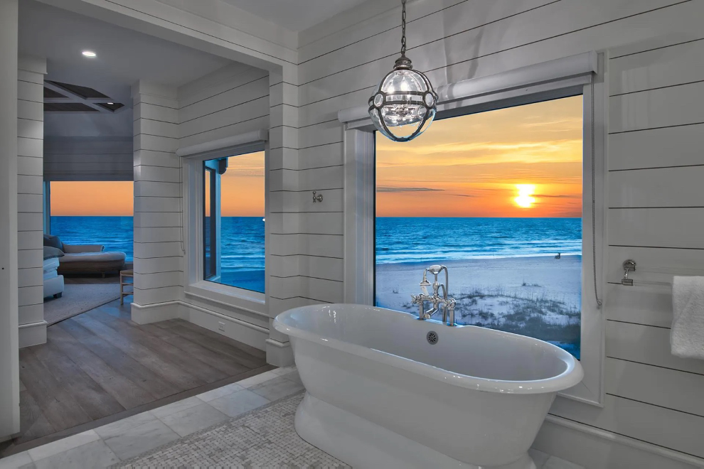 luxurious soaking tub in a bathroom with an ocean view at sunset