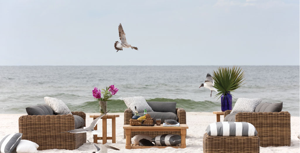 outdoor furniture sitting on the sand on the beach in front of the ocean