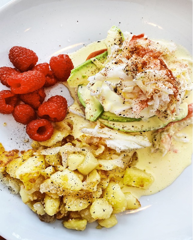Crab and Avocado Eggs Benedict with raspberries and grilled potatoes