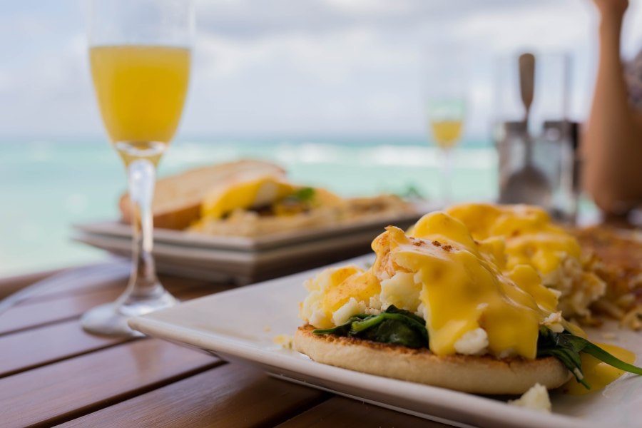 Mimosas and brunch by the beach overlooking turquoise ocean waters