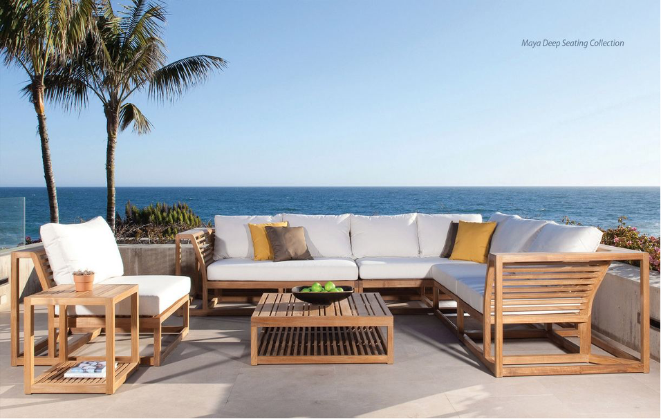 Maya Deep Seating Collection from Westminster Teak on oceanfront patio with palm trees and other foliage.