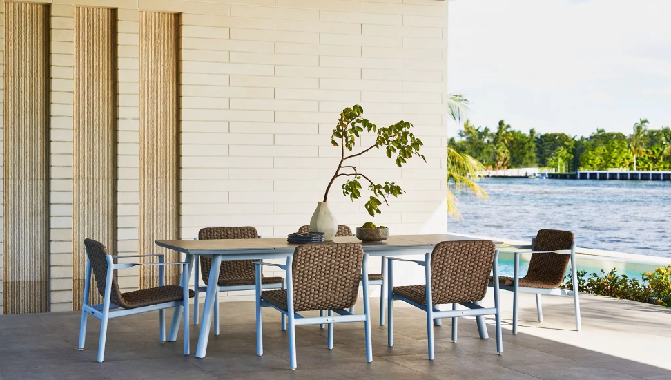 Oscar dining table with Oliver chairs all from Brown Jordan on a waterfront patio.