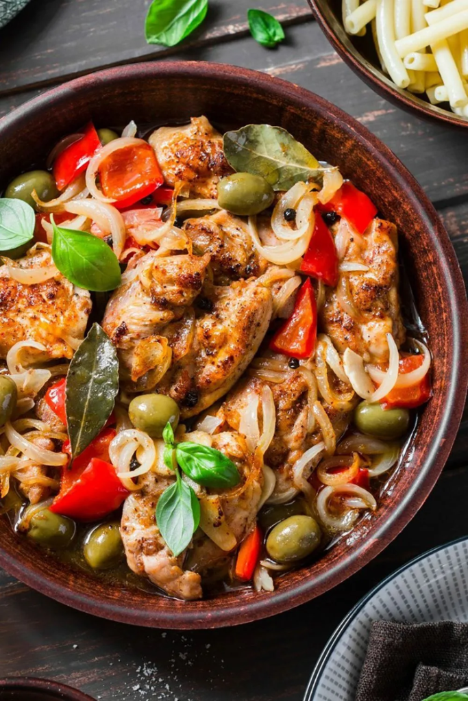Slow-Cooked Mediterranean Chicken with Tomatoes, Olives, and Thyme in serving bowl on rustic table
