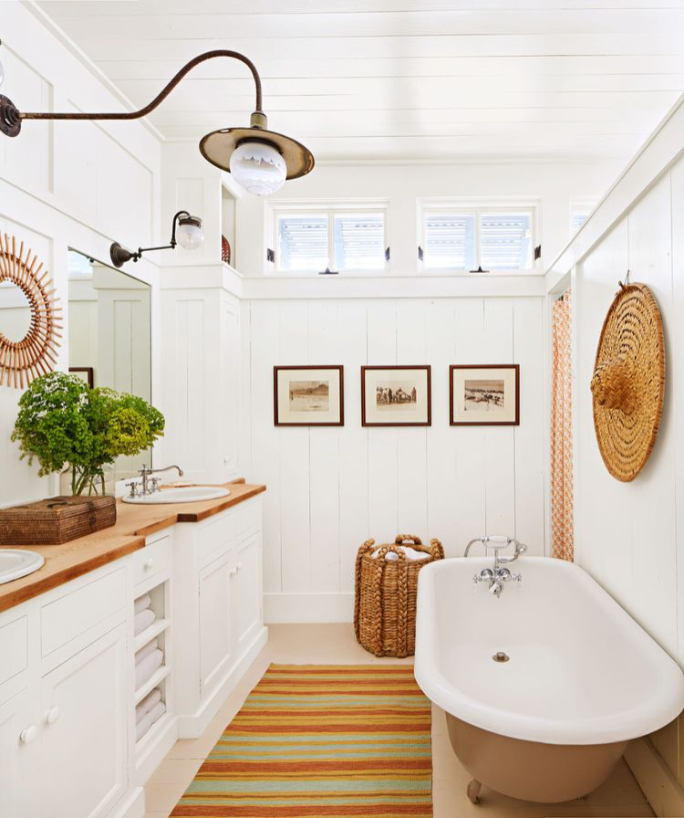 Updated mirror and lighting for a coastal bathroom with a soaking tub all in a retro yet refreshed aesthetic