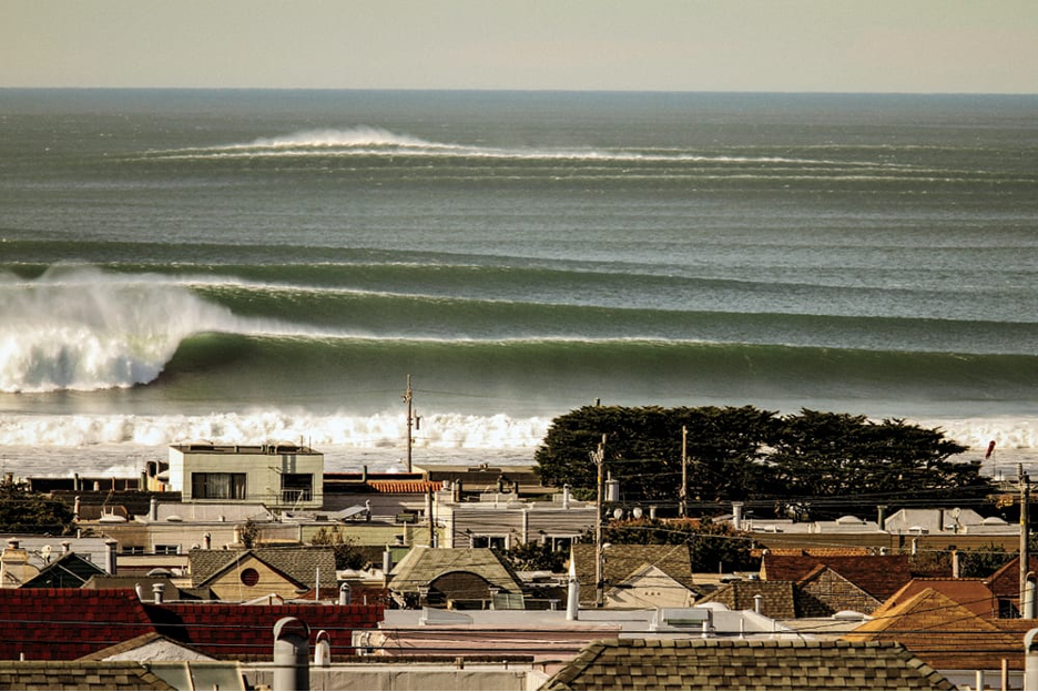 Powerful ocean waves coming in within the surfing community of Ocean Beach, San Francisco, rooftops of homes in the foreground