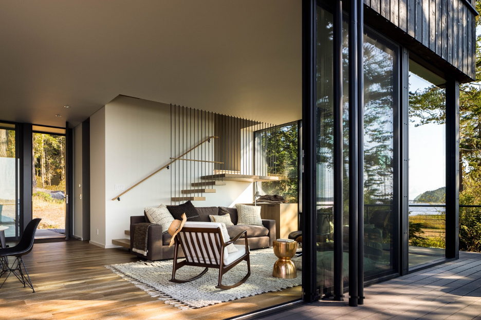 Living area showing staircase to upper levels and connection to the outdoors via folding glass doors