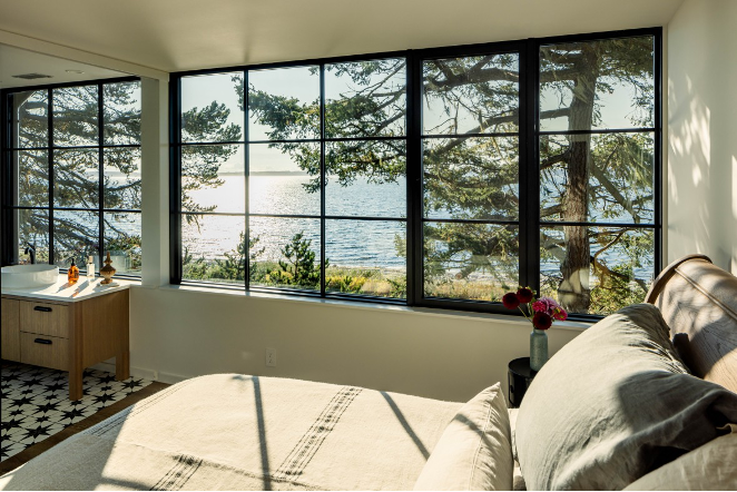 Second-floor bedroom with expansive water views and surrounding trees