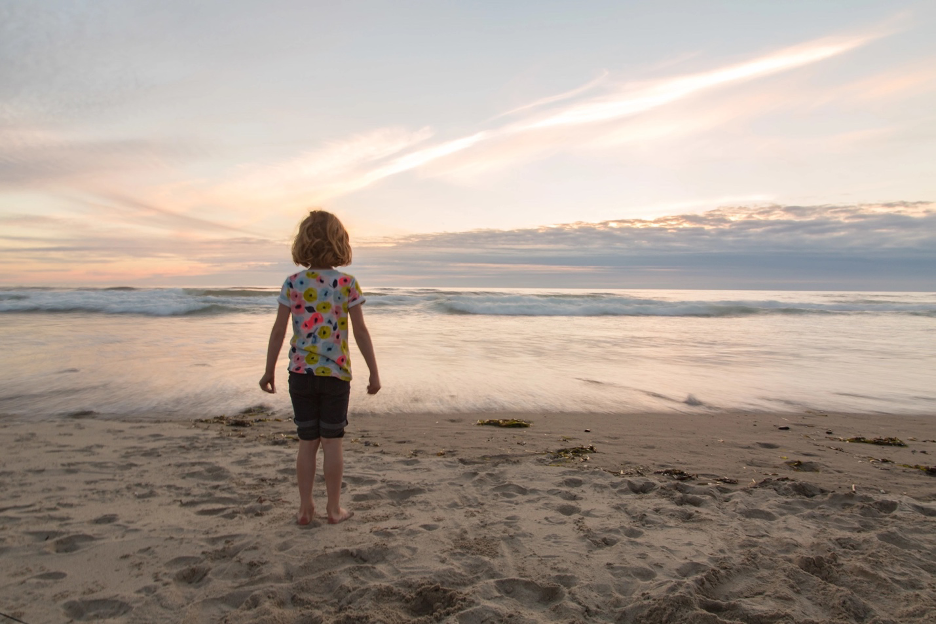 small child standing on the sandy beach at Cape Lookout State Park, Tillamook County, Oregon