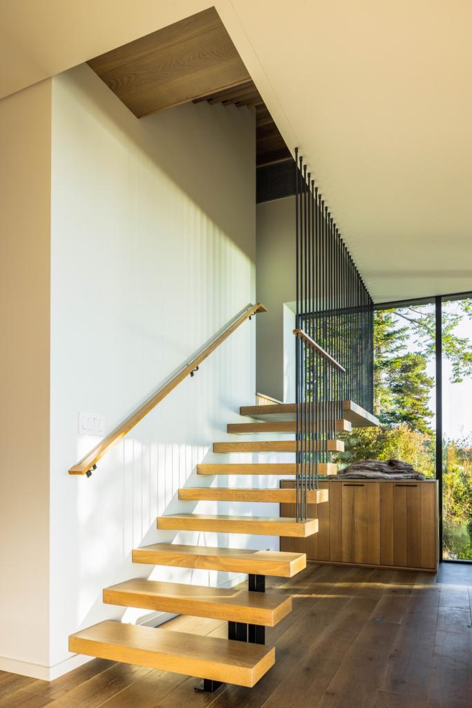 main floor staircase, with architectural embellishments, wooden treads, views to outside
