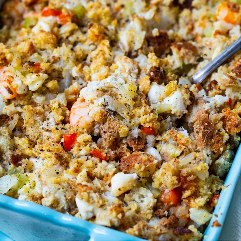 Savannah Seafood Stuffing in a blue casserole dish with serving spoon