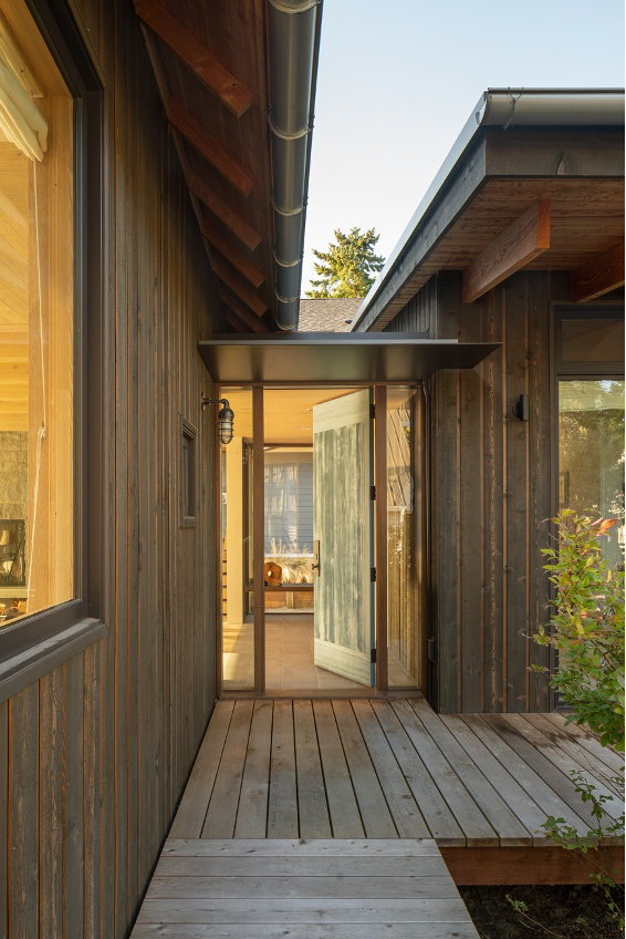 Main entrance between the main home and the other guest volumes; aluminum-clad wood windows and rustic yet smooth wooden walkways