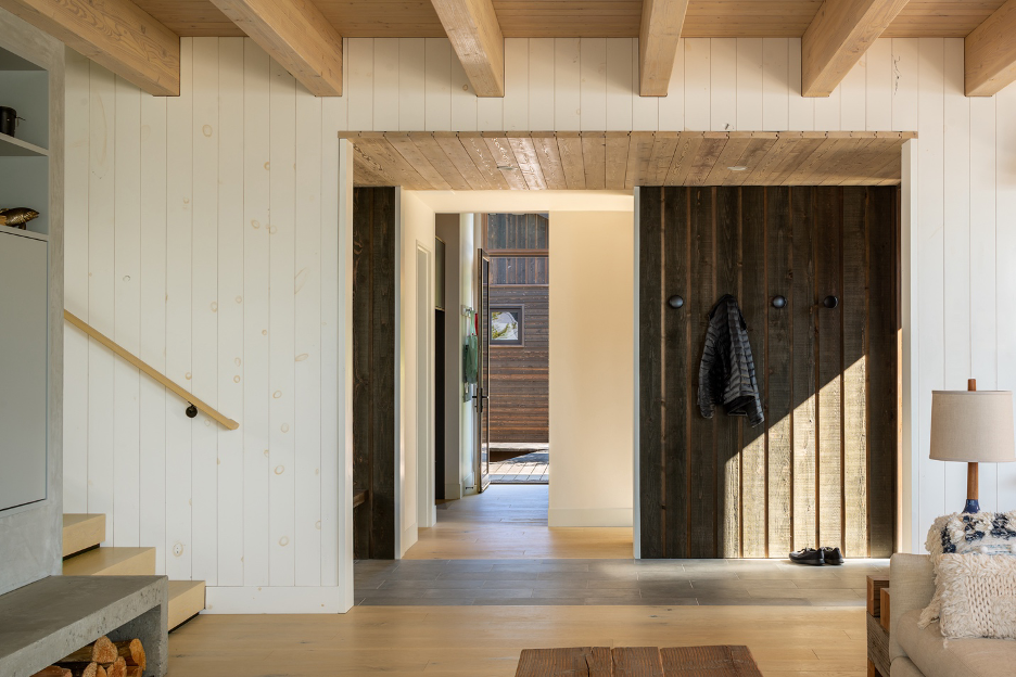Main entrance hall with rustic wood finishes counterbalancing smooth wood beams and white oak-stained  flooring.