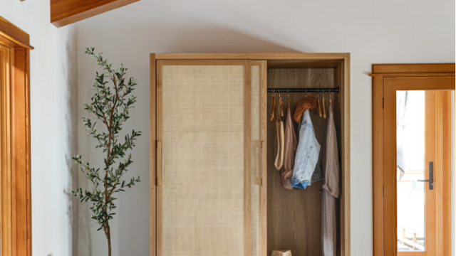 spacious coastal mudroom in large beach home with freestanding storage cabinet and storage bins