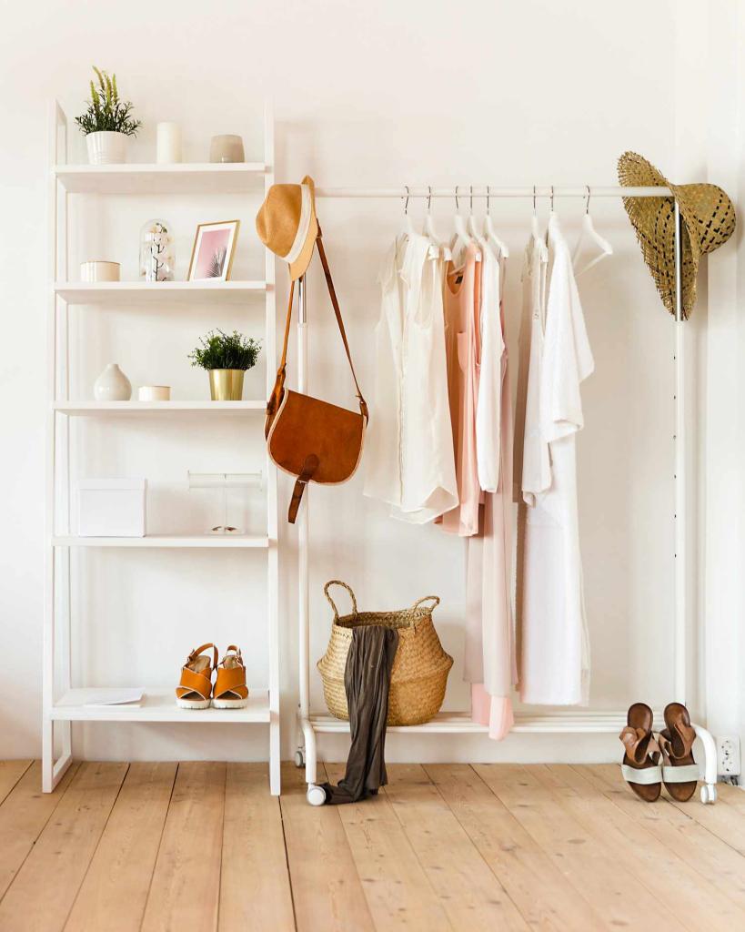 Sculptural Wall Hooks and Open Clothing Displays to optimize storage in a guest beach bedroom without a closet
