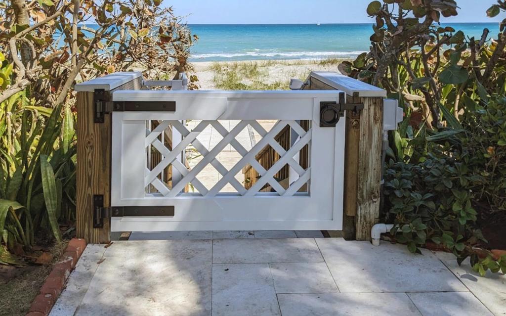 Coastal Garden Gates Framed by Sculptural Trellises
