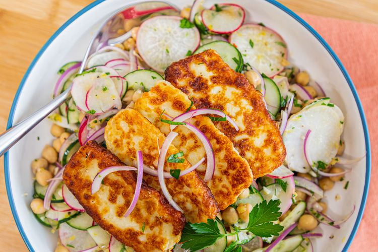 Marinated Chickpea Salad with Radishes, Cucumber & Queso de Freir served in a large bowl with serving spoon.