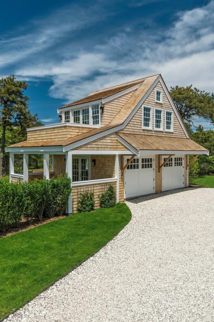 Gladlands Residence, Boston, architecture by Emeritus, interiors by Elisa Allen and build by Geoff Thayer. The shingle-clad detached garage uses a carefully considered roofline, porch and detailing to read as part of the coastal property's architecture rather than an afterthought.